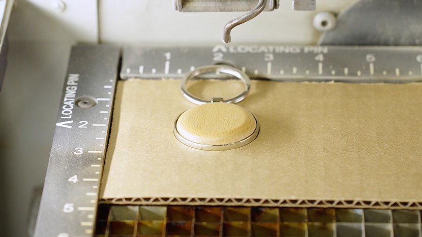 The keychain in the cardboard jig inside the Fusion.