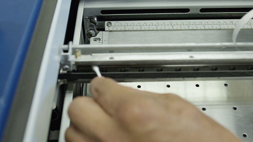 Running a cotton swab along the top of the bearing rail.