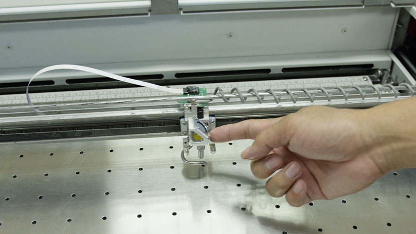 Pushing the lens assembly towards the end of the X-Axis Assembly.