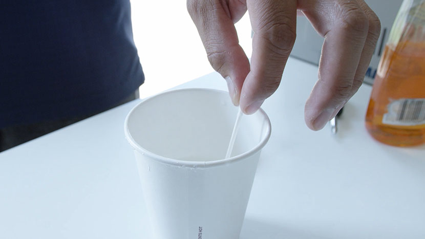 Dipping a cotton swab into soapy water.