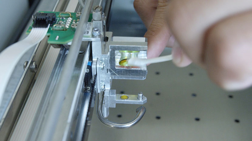 Cleaning the top of the lens with a cotton swab.