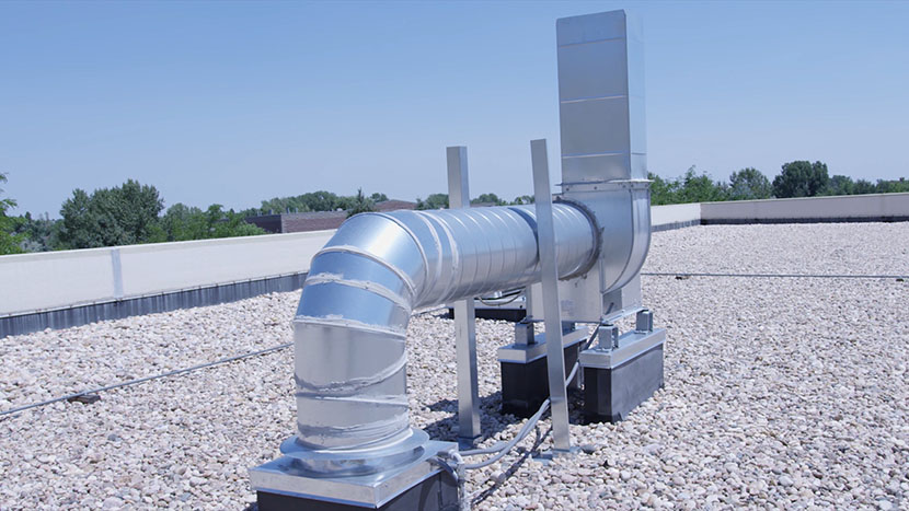 A motor blower on the roof of a building.