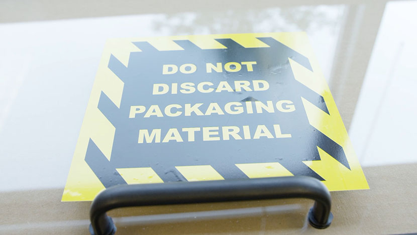 The 'Do Not Discard Packagin Material' Sign on the lid of the machine.