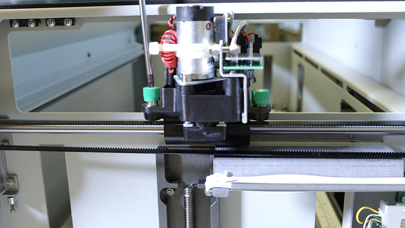 Unscrewing the front captive screw on the right side of the X-Axis Assembly.