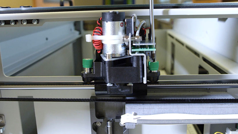 Unscrewing the back captive screw on the right side of the X-Axis Assembly.