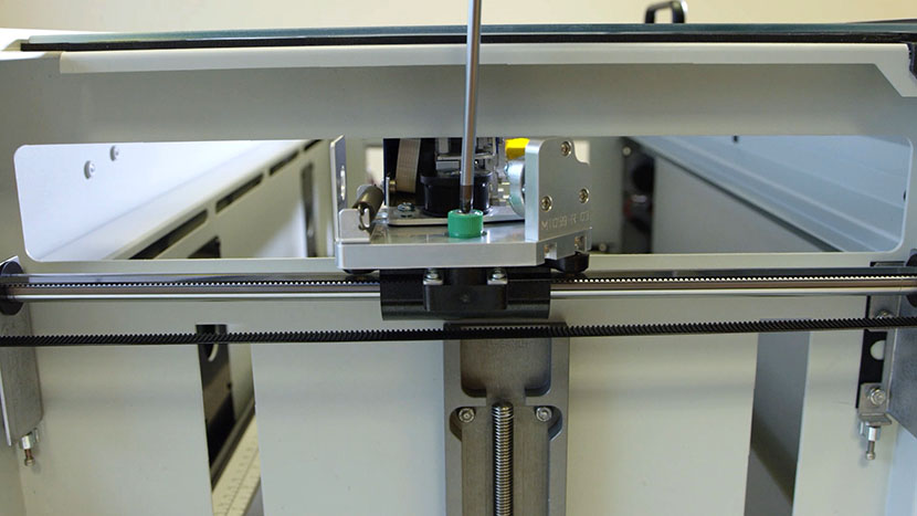 Unscrewing the green captive screw on the left side of the X-Axis Assembly.