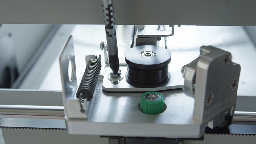 Loosening the screw that holds the sliding plate in place on the left end of the X-Axis Assembly.