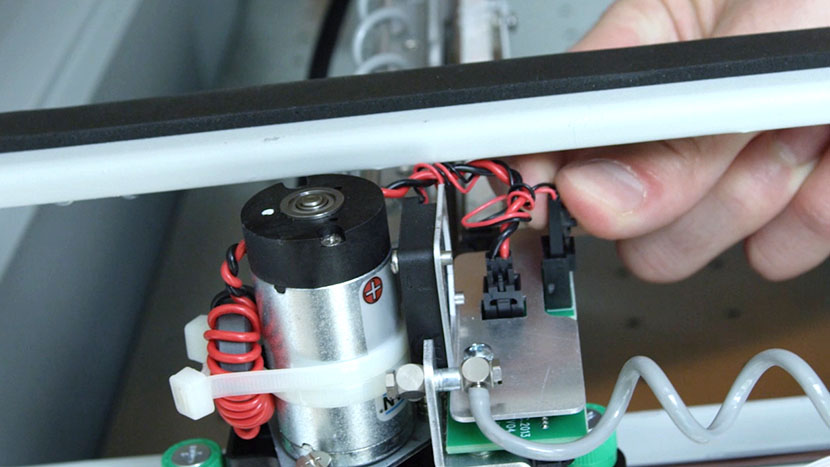 Unscrewing the Air Assist Coil from the end of the X-Axis Assembly.