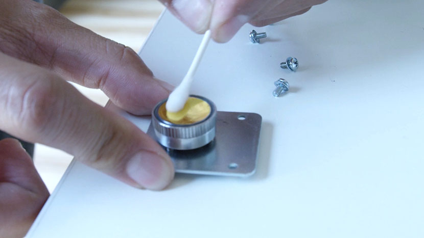 Cleaning the mirror with a cotton swab.