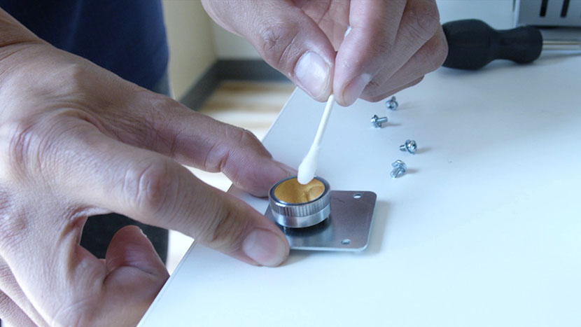 Cleaning the mirror with a cotton swab.