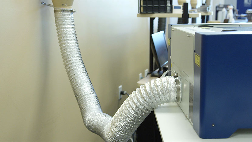 Flexible metal ducting connecting the exhaust port of the laser to the building's ventilation system.