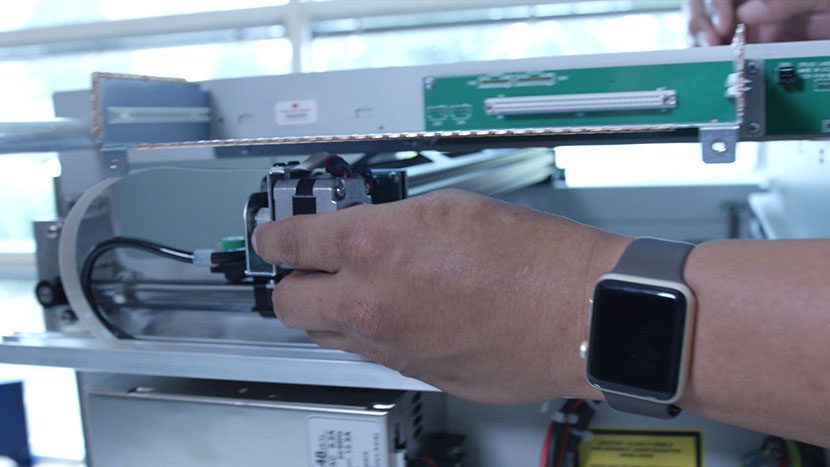 The x-axis assembly being pushed to the front of the machine.