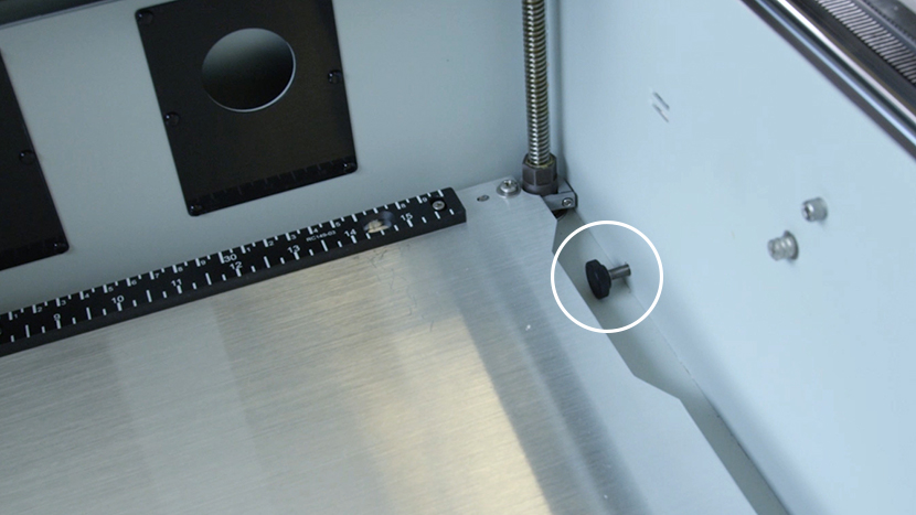 The black-capped tensioning screw on the right side of the interior of the machine.